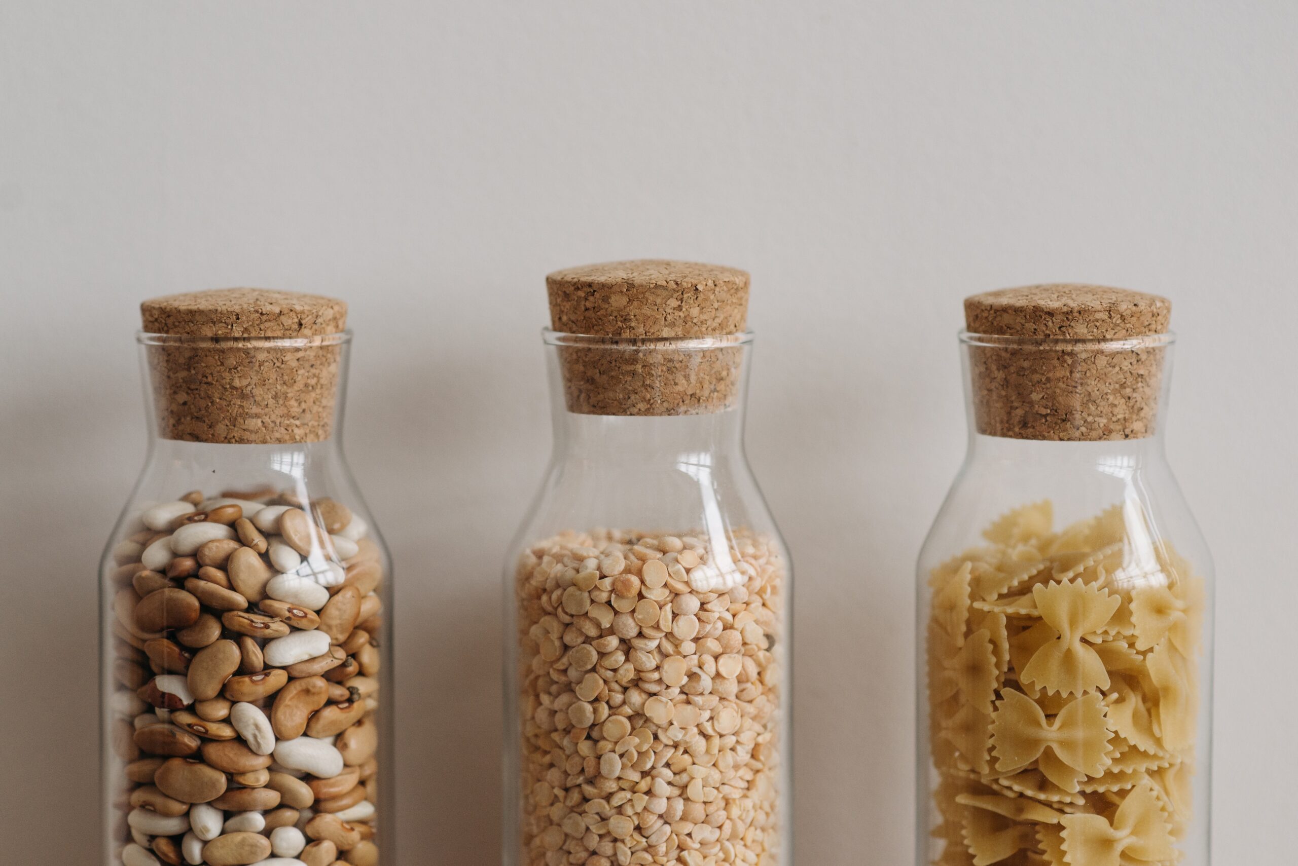 3 containers with dry foods inside, each capped with a cork